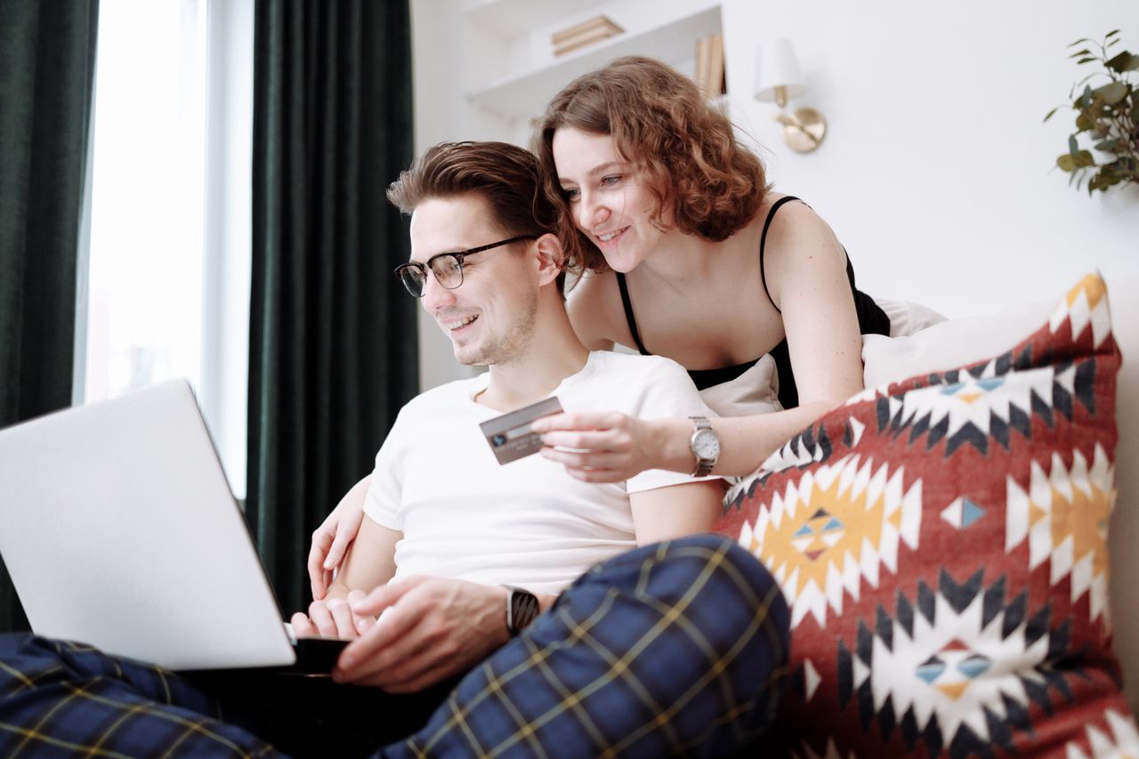 Mastering the First Impression: Your intriguing post title goes here Happy couple using laptop for online shopping while sitting together at home.