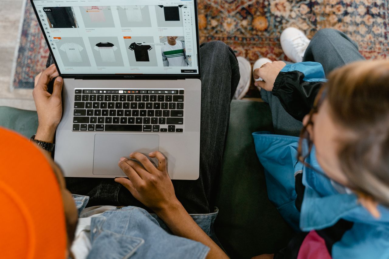 Crafting Captivating Headlines: Your awesome post title goes here Two people browsing online clothing store on a laptop from above.